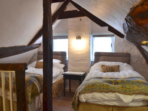 Hale乔尔德黑尔乡村度假屋的阁楼上的卧室配有两张床