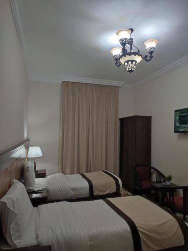 Al ‘Azīzīyahاوتاد المتحدة的酒店客房设有两张床和吊灯。