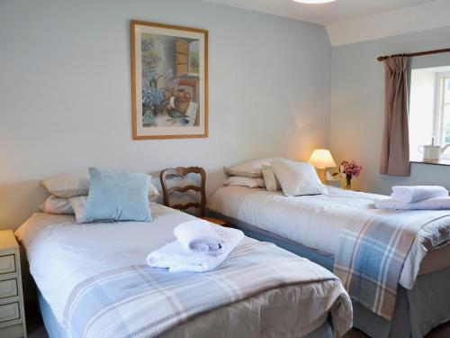 赫斯特蒙苏考比奇农场度假屋的一间卧室配有两张带毛巾的床