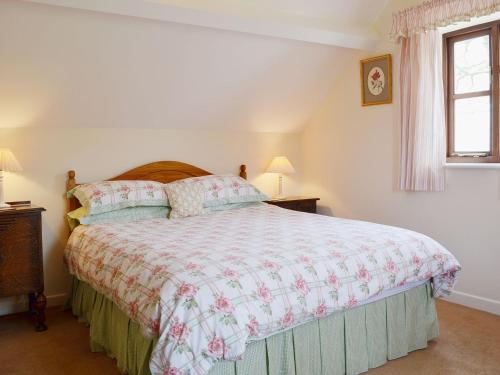 Kinlet草莓小屋乡村别墅的一间卧室设有一张大床和一个窗户。