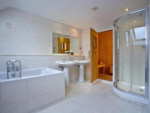 圣维恩Holly的浴室配有2个盥洗盆、浴缸和淋浴。