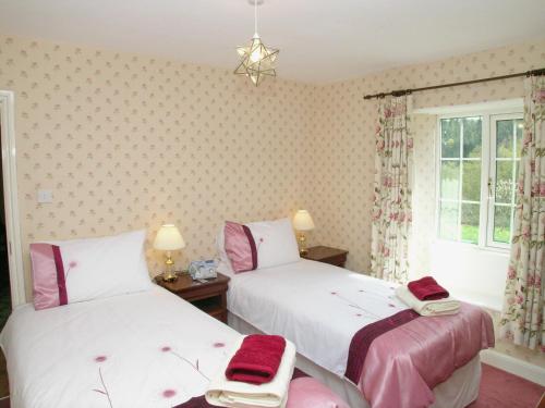 Broxa比克利校舍乡村别墅的粉红色和白色的客房内的两张床