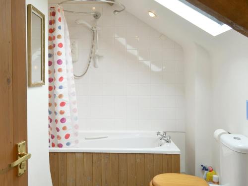 Jacobstow施彭乡村别墅的带浴缸和淋浴帘的浴室