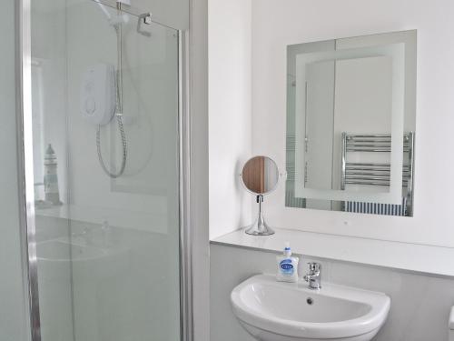基斯高地Morys Cottage的白色的浴室设有水槽和淋浴。