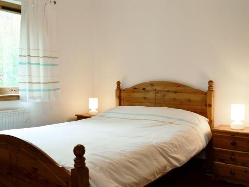格伦芬南布莱斯沃度假屋的一间卧室配有一张带两盏灯的木床。