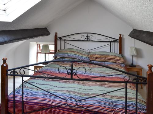 LindaleRose Cottage的一间卧室配有一张带金属框架的床