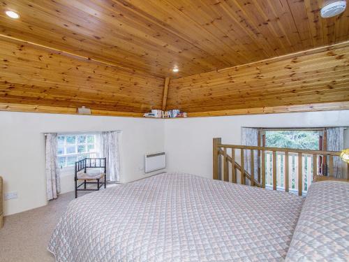 Balnaboth旧洗衣房x乡村别墅的一间卧室设有一张床和木制天花板