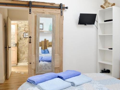 Wrangaton菲格瑞度假屋的一间卧室设有一扇门、镜子和一张床