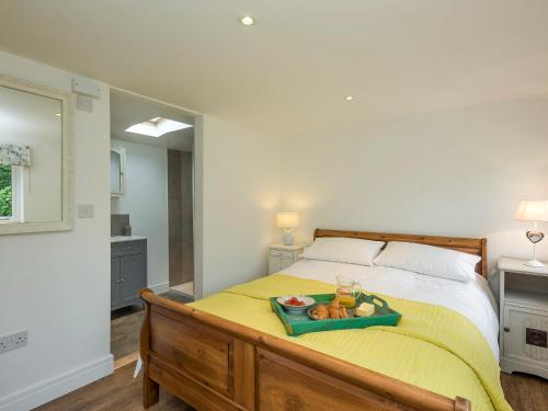 Stoke Holy Cross谷仓猫头鹰度假屋的一间卧室配有一张床,上面有水果盘
