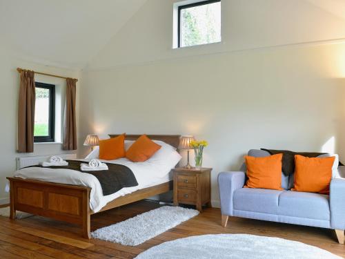 LlangadogDolgoed House的一间卧室配有一张床和一张蓝色的沙发
