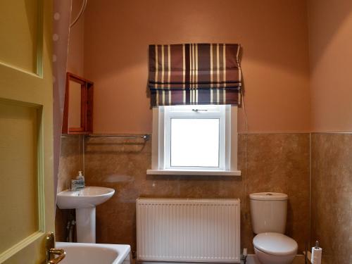 KirtlebridgeBonshawside Farmhouse的一间带水槽和卫生间的浴室以及窗户。