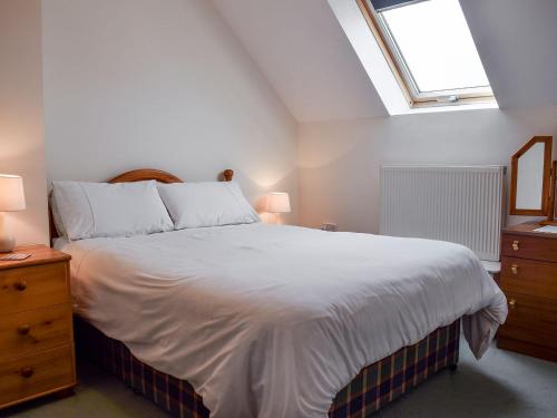 Llangadog玛尔莱斯乡村别墅的卧室配有一张白色的大床和天窗。