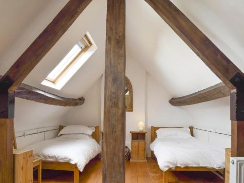 Chadlington南景乡村民宿的阁楼间设有2张床和木梁。
