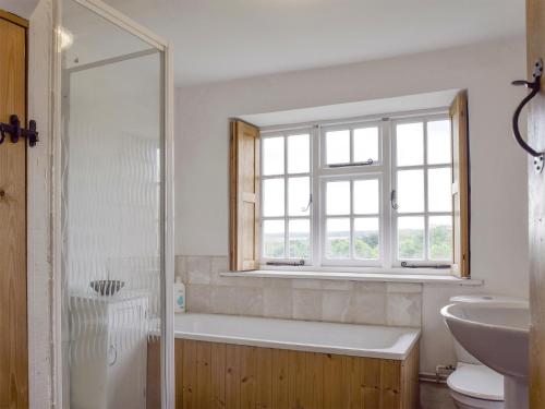 Chadlington南景乡村民宿的带浴缸、水槽和窗户的浴室
