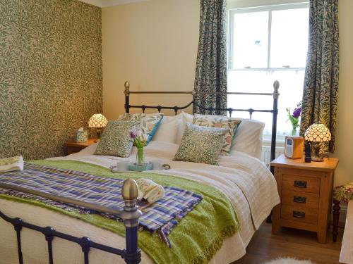 Hollington飞燕草度假屋的一间卧室设有一张床和一个窗口