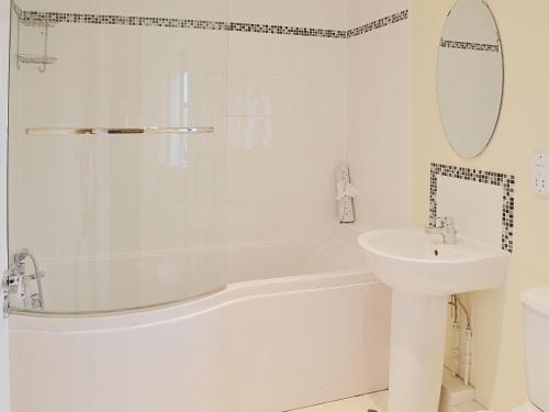 High Halstow干草谷仓乡村别墅的白色的浴室设有水槽和浴缸。