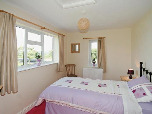Kingsley东菲特度假屋的一间卧室设有一张床和两个窗户。