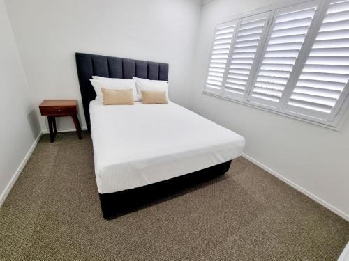 赫维湾Large and Private Executive Home - Secure parking for boats的卧室配有白色的床和窗户。