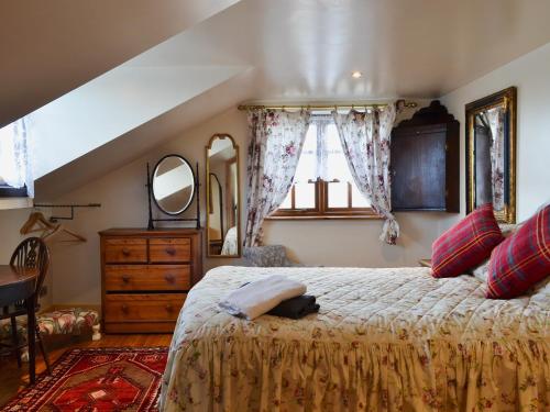 伍尔铁路小屋乡村别墅的一间卧室配有一张床、梳妆台和镜子
