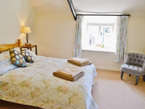KentisbeareFolly Cottage的卧室配有床、椅子和窗户。