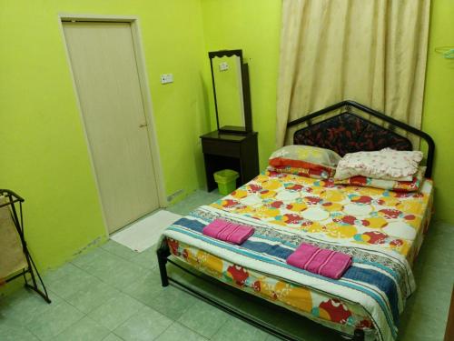 淡文HOMESTAY JANNATI TAMBUN的一间卧室配有一张带色彩缤纷的床单和枕头的床。