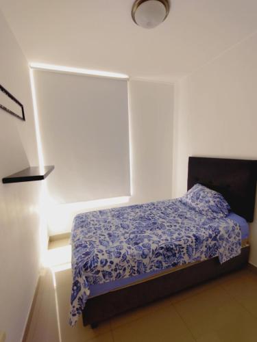 皮乌拉Acogedor Departamento 3 Hab Piura的一间卧室配有一张带蓝色棉被的床
