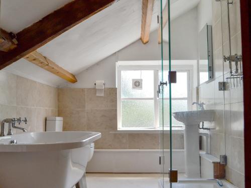 LlandybieThe Mill Farmhouse的浴室配有盥洗盆、卫生间和浴缸。