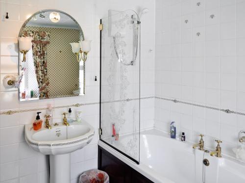 彭赞斯小蓝屋乡村别墅的带淋浴、盥洗盆和浴缸的浴室