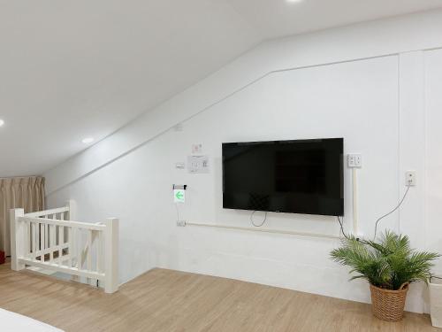 台南白色苏打的客厅配有白色墙壁上的平面电视。