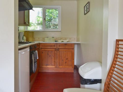 CotePoplar Cottage的一个带木制橱柜和窗户的小厨房