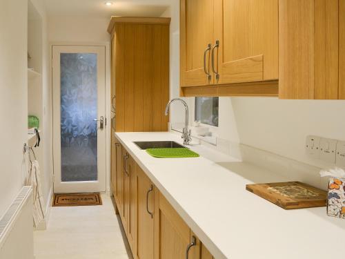 格拉斯米尔客栈度假屋的一个带木制橱柜和水槽的厨房