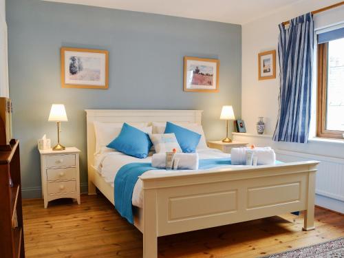 阿伯加文尼德雷格度假屋的一间卧室配有一张带蓝色和白色枕头的床