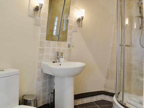 CoedanaThe Windmill的浴室配有白色水槽和淋浴。