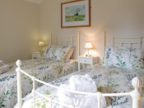 West LuttonThe Old Forge的卧室内的两张床,配有蓝色和白色的床上用品