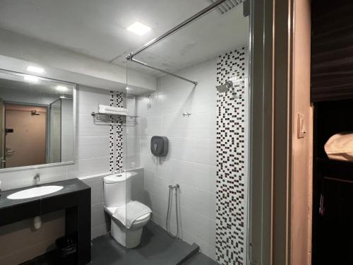 关丹招牌酒店的一间带卫生间、水槽和镜子的浴室