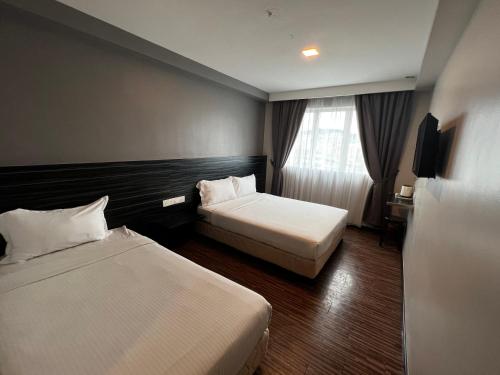 关丹招牌酒店的酒店客房设有两张床和窗户。