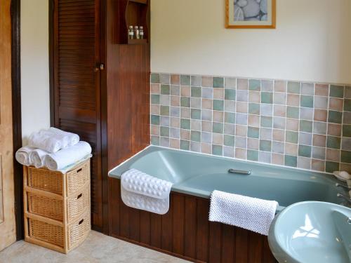 MarthamHalf Moon Cottage的带浴缸和盥洗盆的浴室