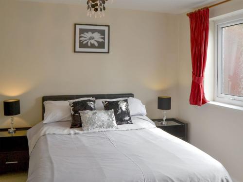 霍宁塔卡拉乡村别墅的一间卧室配有带白色床单和枕头的床。