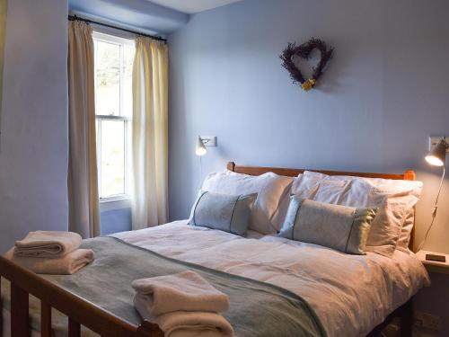 Far SawreyLetterbox Cottage的一间卧室配有带毛巾的床