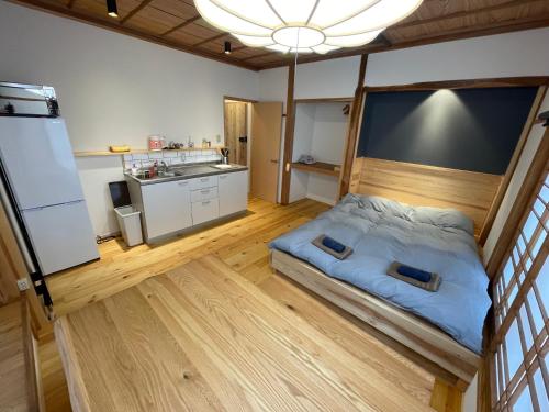 野沢Yubaba House Downtown Apartments的一间带床的小卧室和一间厨房