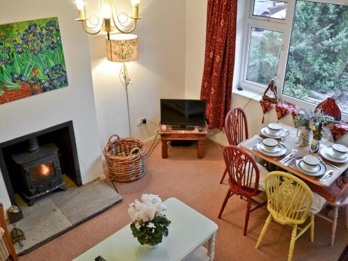 Fordwich雪松乡村别墅的客厅配有桌子和壁炉