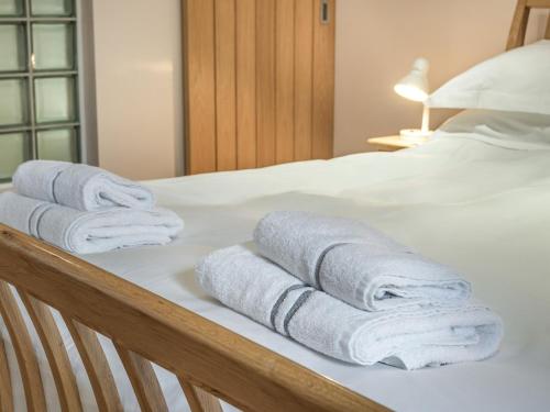 霍利黑德Stack View Cottage的一组毛巾,放在床上