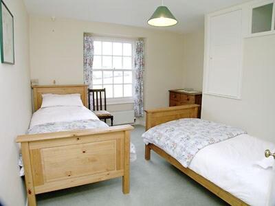 Loders苹果树乡村别墅的一间卧室设有两张床和窗户。