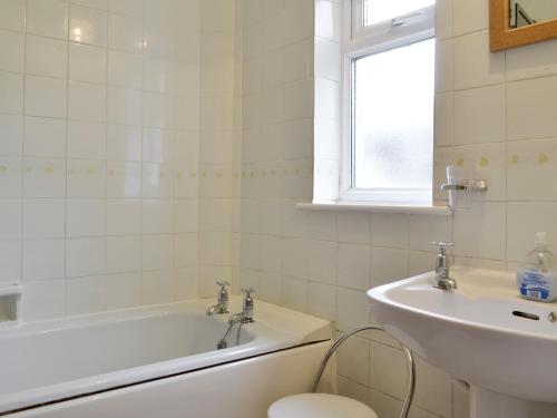 Pilton沃尔特斯别墅酒店的白色的浴室设有浴缸和水槽。