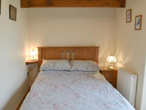 PlymtreeOrchard View Barn的一间卧室配有一张床和两个带灯的床头柜