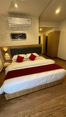 蒂鲁帕蒂KVP GOLDEN INN的一间卧室配有一张带红色枕头的大床