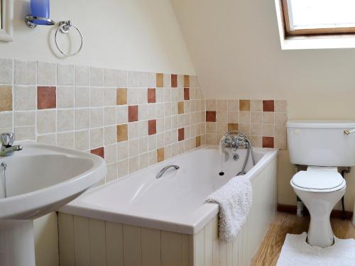 水上伯顿红陶别墅的带浴缸、卫生间和盥洗盆的浴室
