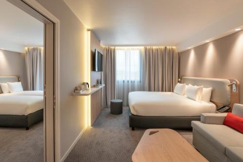 贝利罗曼维利而Holiday Inn Express - Marne-la-Vallée Val d'Europe, an IHG Hotel的酒店客房,设有两张床和一张沙发