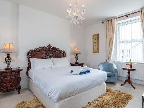 托基Babbacombe Bay, Torquay的卧室配有一张白色大床和吊灯。