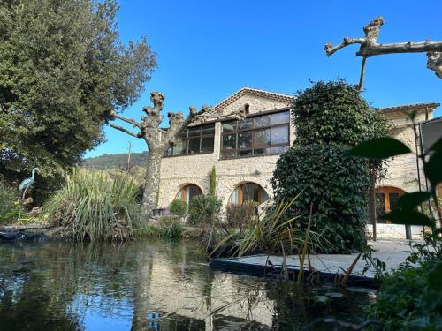 圣马丁阿尔代什Le Mas di Ro的前面有池塘的房子